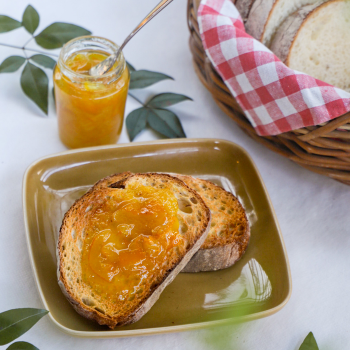 Bread topped with organic yuzu marmalade and bottle of the product