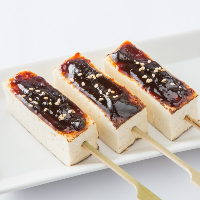 A plate of three tofu skewers topped with miso