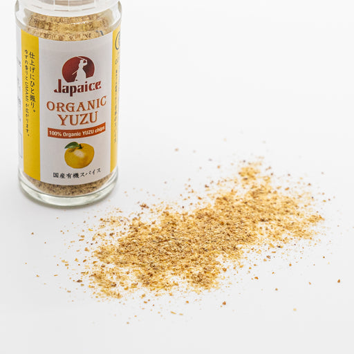 Scattered organic yuzu powder next to a bottle of the product