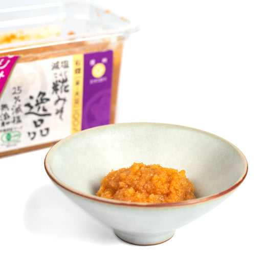 A small bowl of organic koji miso next to box of the product