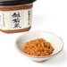 A bowl of miso paste next to a box of the product