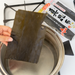 Overhead shot of hand putting ma-kombu into boiled water