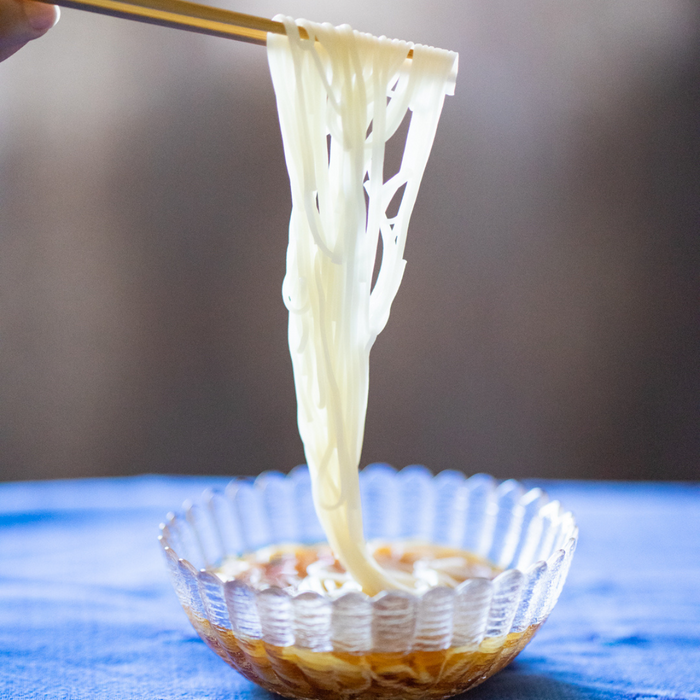 Man dipping somen noodles into mentsuyu sauce