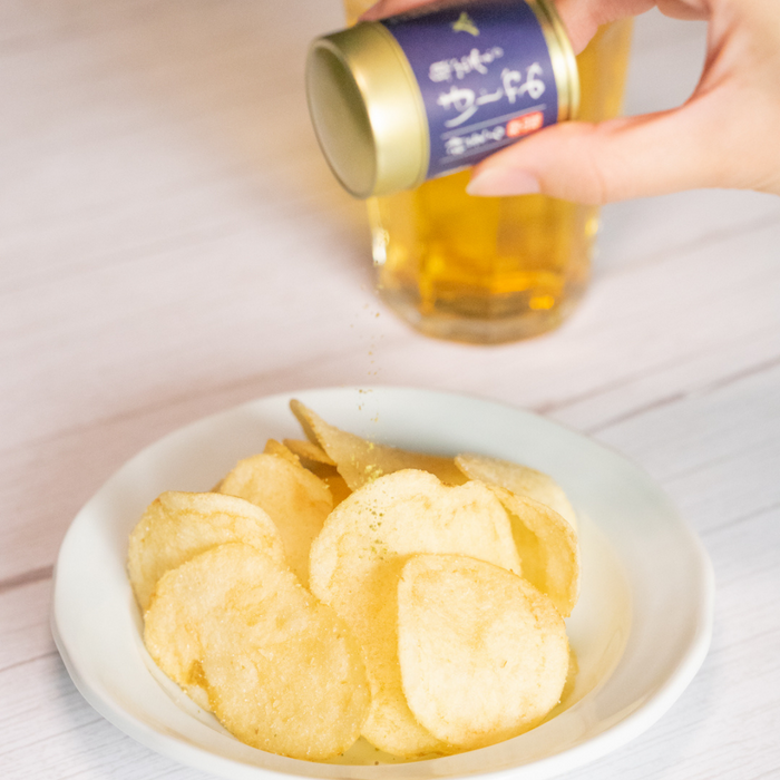 Man sprinkling sansho pepper onto potato chips