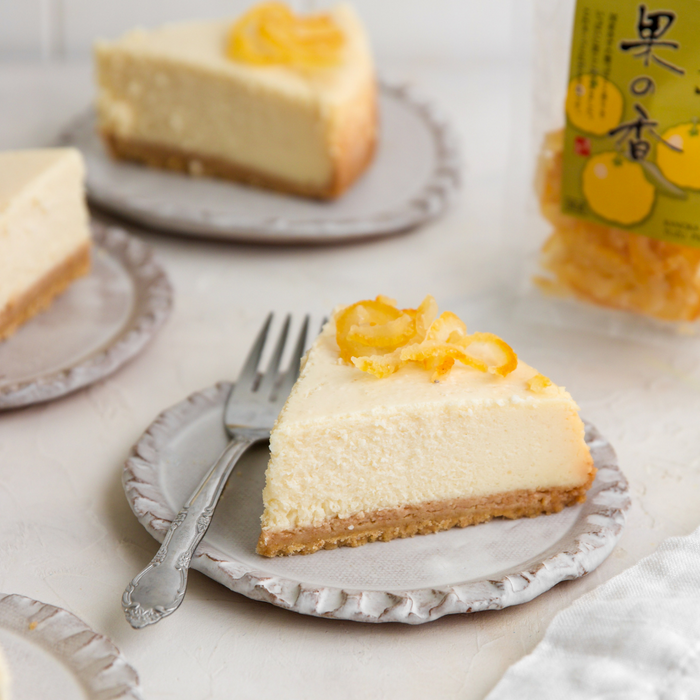 A slice of cheese cake topped with dry candied yuzu peel
