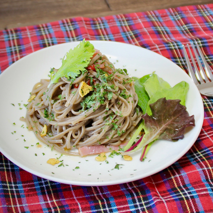 A plate of cold juwari soba noodles topped with garnish