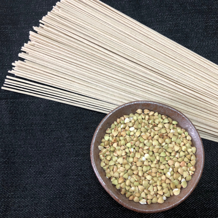 A bowl of buckwheat seeds next to dried juwari soba noodles