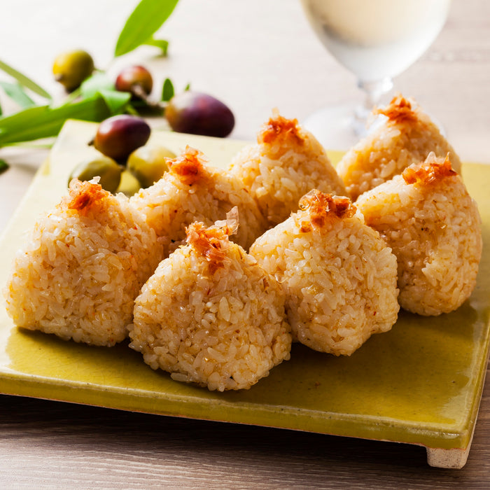 Seven pieces of onigiri rice balls topped with soy sauce soaked bonito flakes
